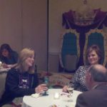 Image of two women and a man sitting at a table talking