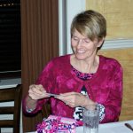 Image of Linda Sturm with short blond hair opening a gift