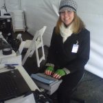 Image of a captioner with her stenography machine and a coat, hat, and scarf